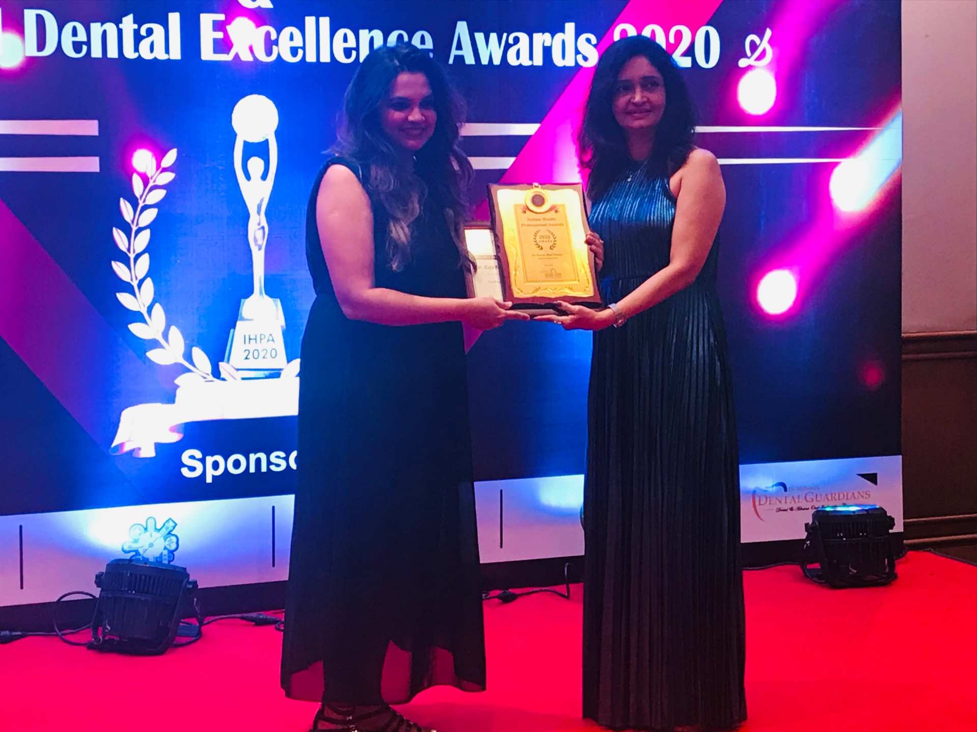 Dr. Kavita Bhat Kumar receiving Dental Excellence Award 2020 on stage