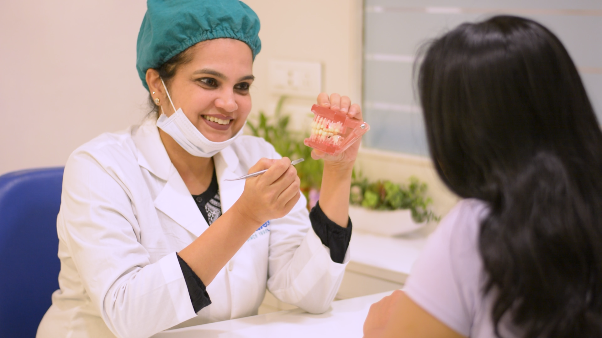 Dr. Kavita explaining a treatment plan to a patient at Designer Smiles